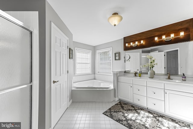 bathroom featuring tile patterned floors, a garden tub, a sink, and double vanity