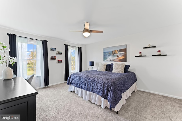 bedroom featuring light carpet, a ceiling fan, and baseboards