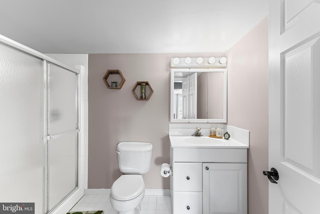 full bath featuring a shower stall, tile patterned floors, vanity, baseboards, and toilet
