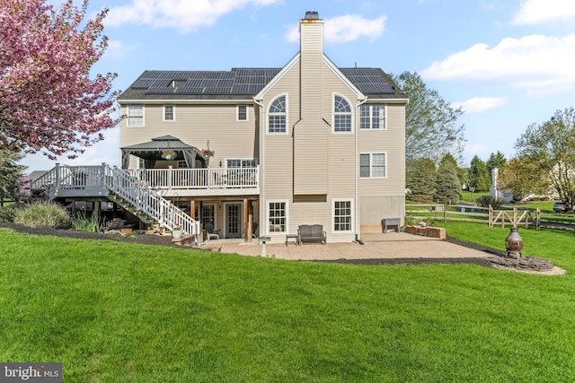 rear view of property with solar panels, a gazebo, a yard, and a patio