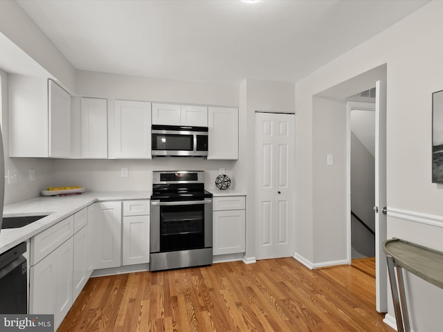 2607 Nisqually Ct, Silver Spring, MD 20906 - kitchen featuring white cabinets, light wood-style flooring, stainless steel appliances, and baseboards