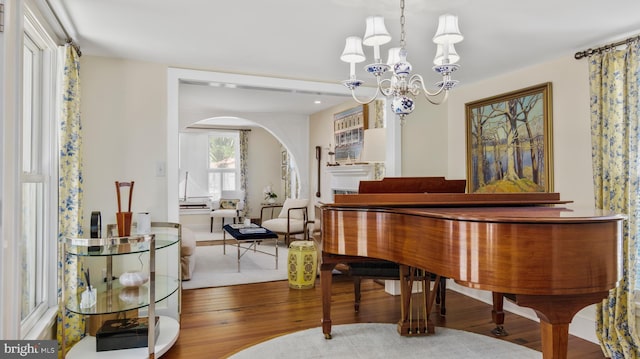213 S Morris St, Oxford, MD 21654 - interior space with arched walkways, wood finished floors, and a notable chandelier