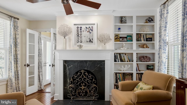 213 S Morris St, Oxford, MD 21654 - sitting room featuring built in shelves, ceiling fan, wood finished floors, and a premium fireplace