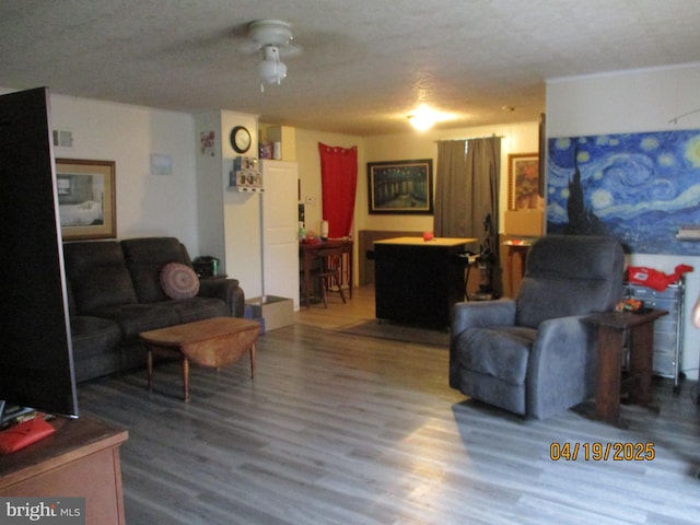 living area with wood finished floors and ceiling fan