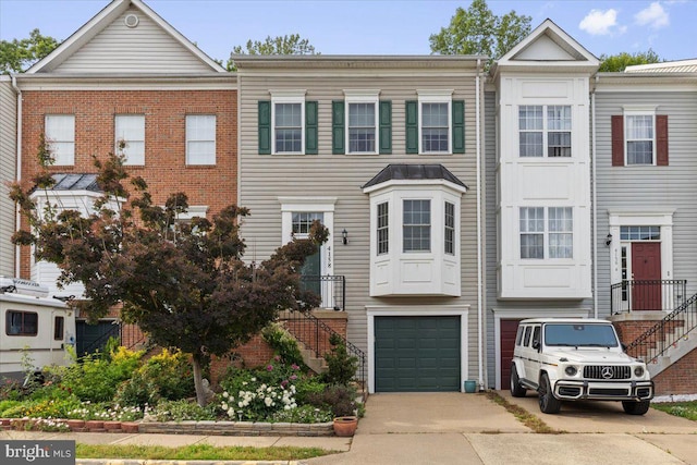townhome / multi-family property featuring concrete driveway and a garage