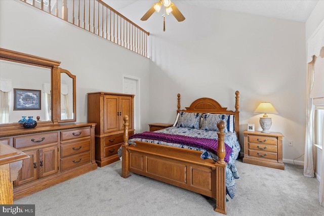 bedroom featuring light carpet, a towering ceiling, and ceiling fan