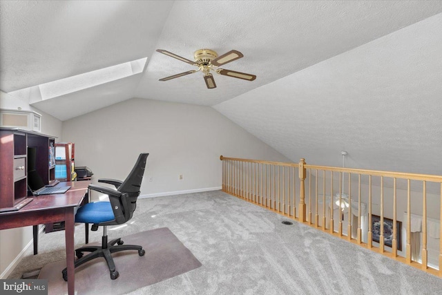 carpeted office space with ceiling fan, a textured ceiling, vaulted ceiling, and baseboards