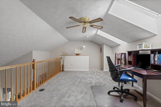 carpeted office with a skylight, a textured ceiling, lofted ceiling, ceiling fan, and baseboards