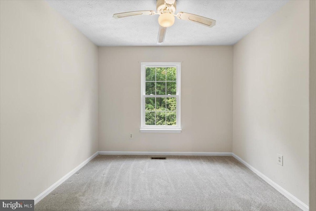 unfurnished room with carpet flooring, a textured ceiling, a ceiling fan, and baseboards