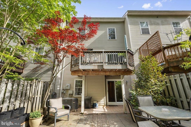 rear view of house featuring a balcony, a patio area, a fenced backyard, cooling unit, and outdoor dining area