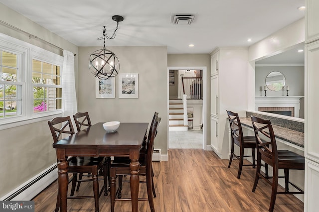 2609 Turf Valley Rd, Ellicott City, MD 21042 - dining space with a notable chandelier, baseboard heating, wood finished floors, visible vents, and stairway