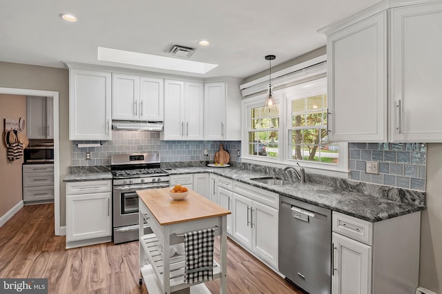 2609 Turf Valley Rd, Ellicott City, MD 21042 - kitchen with wooden counters, visible vents, appliances with stainless steel finishes, a sink, and under cabinet range hood