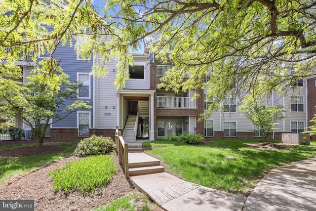 view of front of house with a front yard and brick siding