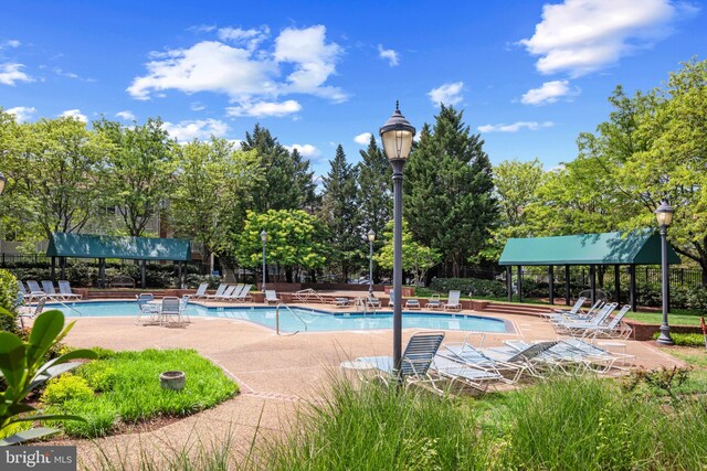 community pool with a gazebo and a patio area