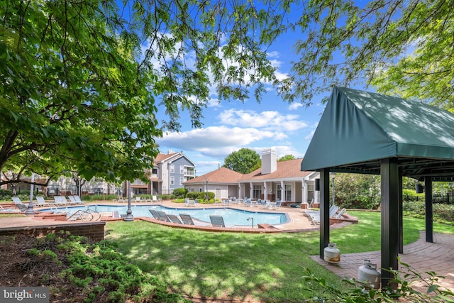 community pool featuring a lawn and a patio