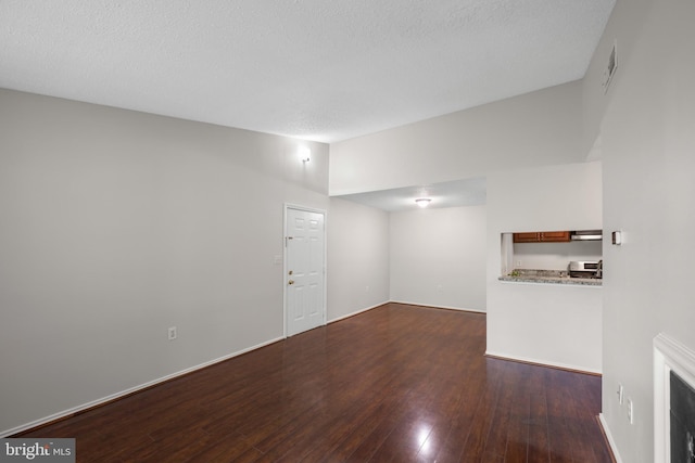 unfurnished living room featuring wood-type flooring, a textured ceiling, and visible vents