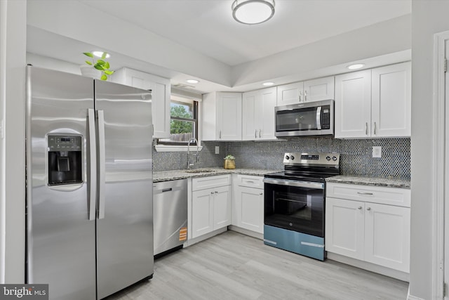 102 Orchard Ct, Royersford, PA 19468 - kitchen with appliances with stainless steel finishes, a sink, white cabinets, light wood-style floors, and decorative backsplash