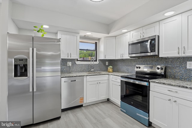 102 Orchard Ct, Royersford, PA 19468 - kitchen with stainless steel appliances, a sink, white cabinets, light wood-type flooring, and tasteful backsplash