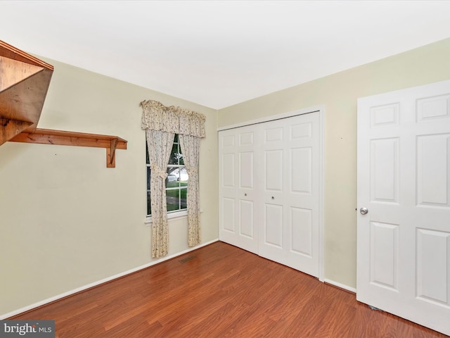 7250 Single Wheel Path, Columbia, MD 21046 - unfurnished bedroom with wood finished floors, a closet, and baseboards