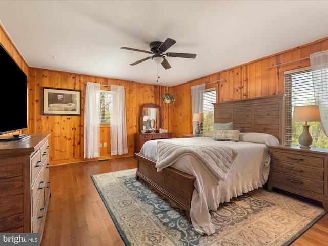 189 Oak Haven Ln, New Market, VA 22844 - bedroom with light wood-style floors, ceiling fan, wooden walls, and multiple windows
