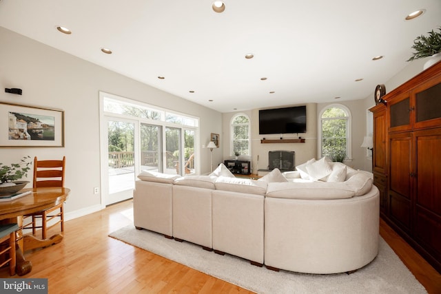 living room featuring light wood-type flooring, recessed lighting, and baseboards