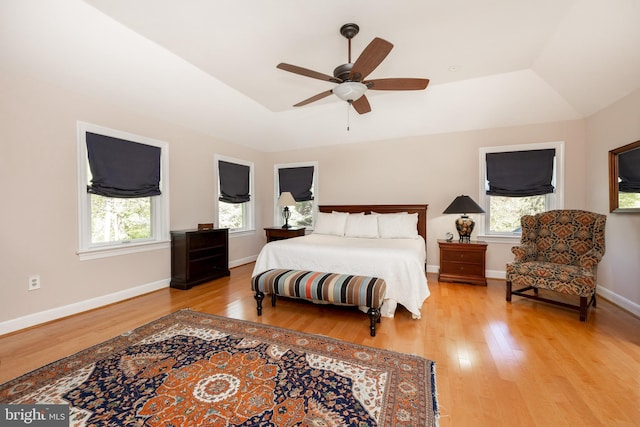 bedroom with baseboards, multiple windows, and light wood-style flooring