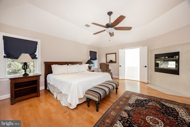 bedroom featuring ceiling fan, lofted ceiling, light wood-type flooring, and visible vents