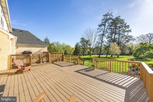 wooden terrace featuring a lawn
