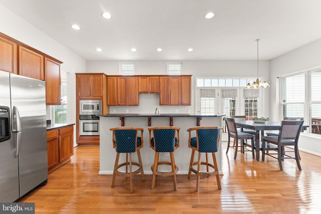 17435 Lethridge Cir, Round Hill, VA 20141 - kitchen with stainless steel appliances, recessed lighting, dark countertops, light wood-style floors, and brown cabinetry