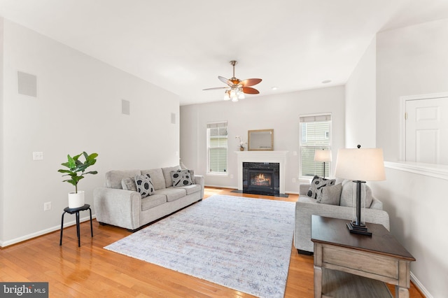 17435 Lethridge Cir, Round Hill, VA 20141 - living area with ceiling fan, light wood-type flooring, a fireplace with flush hearth, and baseboards