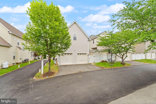 17435 Lethridge Cir, Round Hill, VA 20141 - view of front of house featuring driveway, a garage, a residential view, fence, and central AC