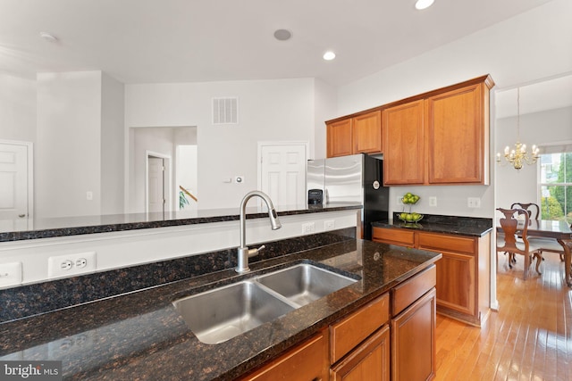 17435 Lethridge Cir, Round Hill, VA 20141 - kitchen with a sink, stainless steel fridge, brown cabinetry, a chandelier, and recessed lighting