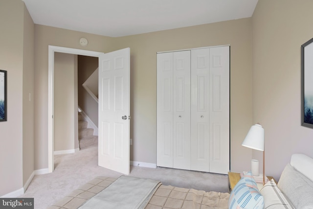 bedroom featuring baseboards, carpet, and a closet