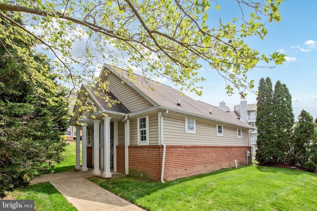 view of side of property with a yard and brick siding