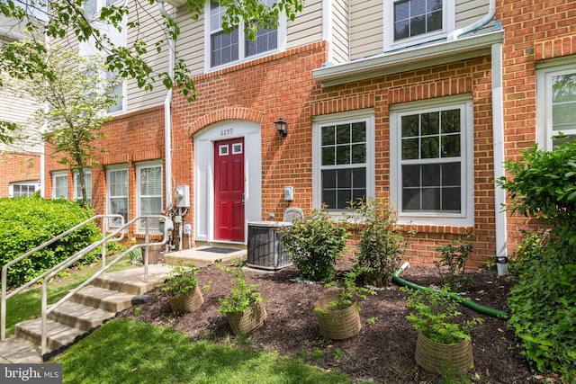 doorway to property with central air condition unit and brick siding