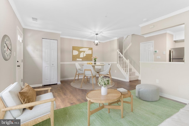 living room with stairway, baseboards, crown molding, and wood finished floors