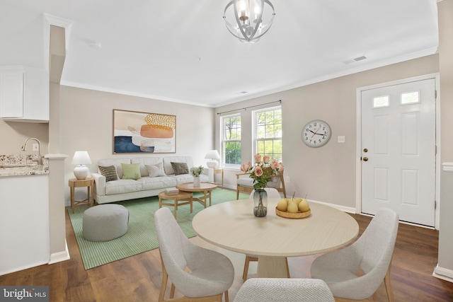 dining area featuring crown molding, baseboards, visible vents, and dark wood-type flooring