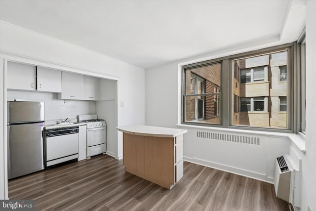 kitchen featuring a sink, white appliances, light countertops, dark wood-type flooring, and a kitchen island