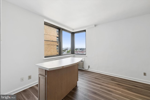 unfurnished office featuring baseboards and dark wood-style floors