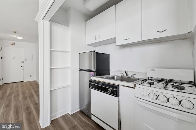 kitchen with white appliances, dark wood-type flooring, light countertops, white cabinets, and a sink