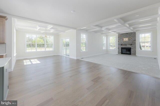 unfurnished living room featuring baseboards, coffered ceiling, and light wood-style flooring