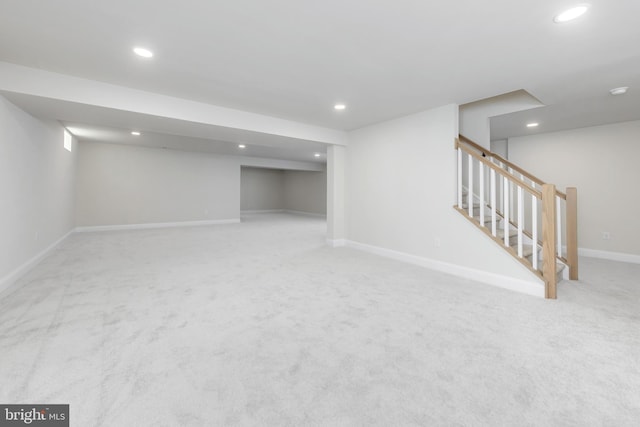 finished below grade area with carpet floors, baseboards, recessed lighting, and stairs
