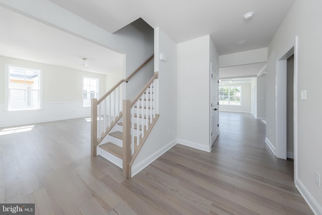 staircase with baseboards and wood finished floors