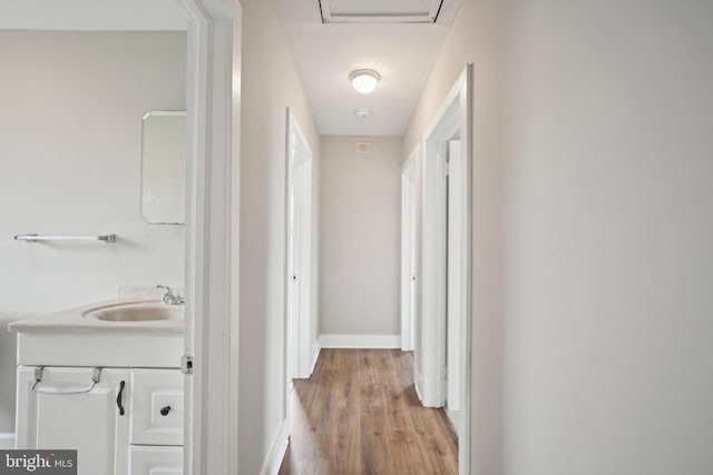 673 Harrisonville Rd, Swedesboro, NJ 08085 - corridor featuring baseboards, a sink, and light wood finished floors