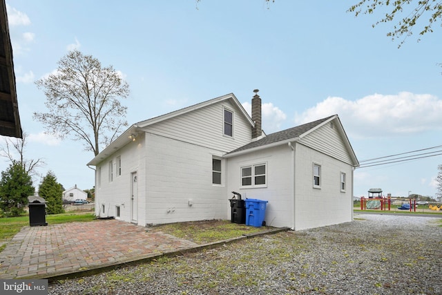 673 Harrisonville Rd, Swedesboro, NJ 08085 - rear view of house with concrete block siding, a chimney, and a patio