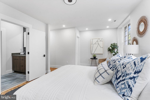 bedroom with recessed lighting, wood finished floors, visible vents, a sink, and baseboards