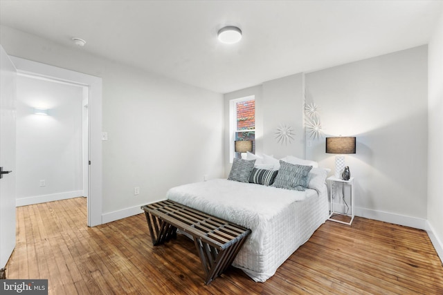 bedroom featuring wood-type flooring and baseboards