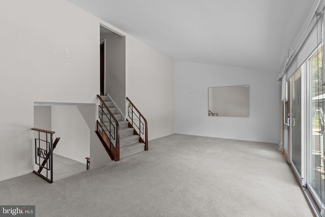 interior space with vaulted ceiling and carpet