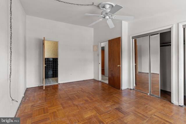 unfurnished bedroom featuring connected bathroom, baseboards, a ceiling fan, and a closet