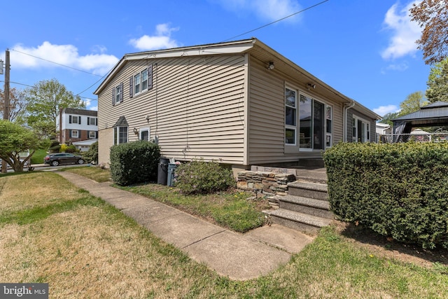 view of side of property featuring a lawn and a gazebo